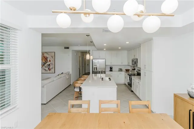 a large white kitchen with a table and chairs