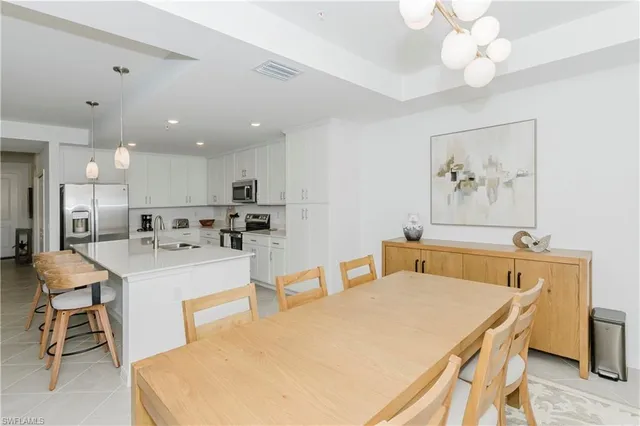 a large white kitchen with a white table and chairs