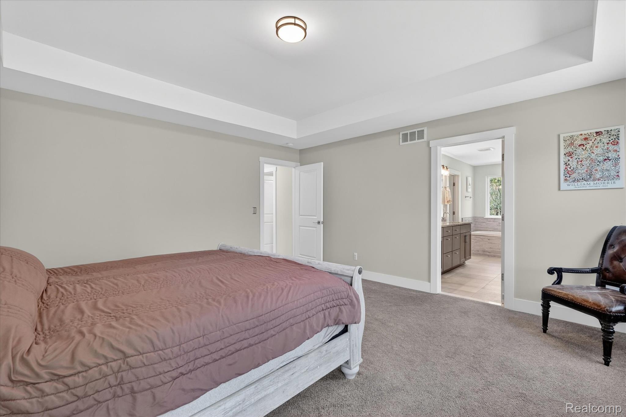 8130 Hinchey Road Pinckney, MI 48169 - Photo 25 of 62 Bedroom featuring a raised ceiling, carpet flooring, and ensuite bath