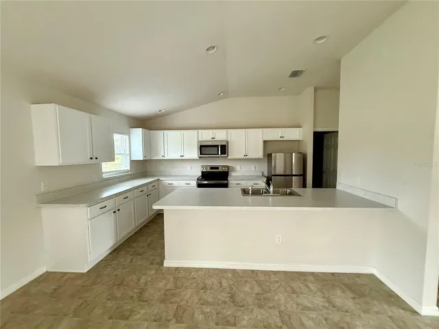 a large white kitchen with a large window