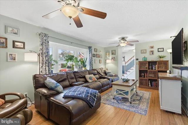 a living room with furniture a flat screen tv and a window