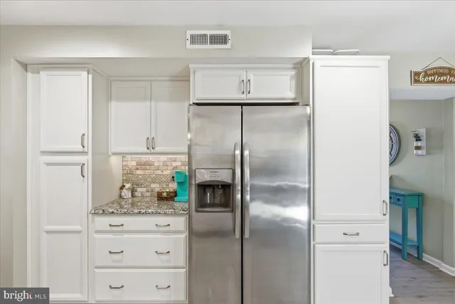 a kitchen with cabinets stainless steel appliances and a refrigerator