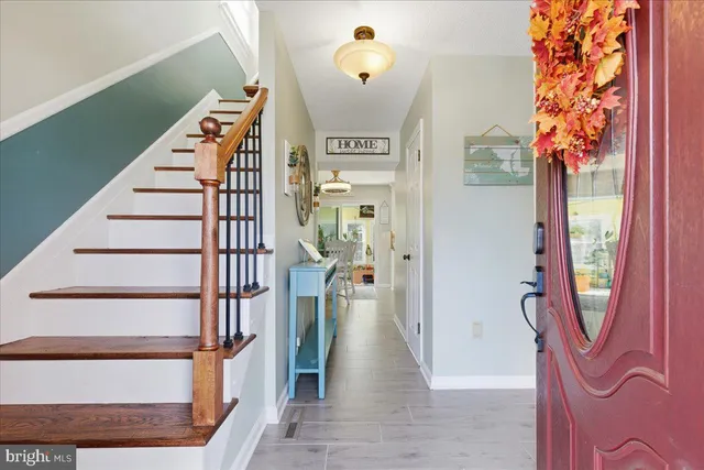 a view of a hallway with wooden floor and staircase