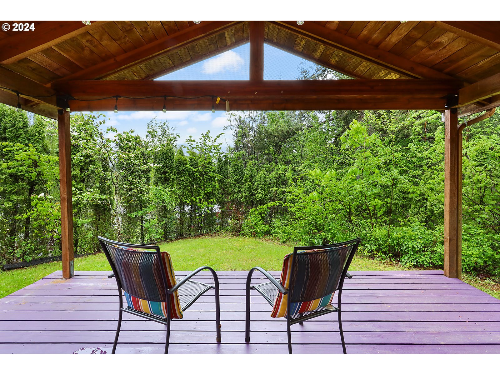 6972 East Loop Road Stevenson, WA 98648 - Photo 3 of 48 a patio with wooden floor a yard a table and chairs