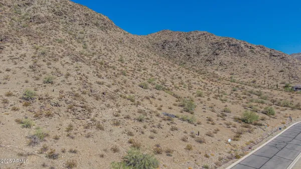 a view of a dry yard with mountains in the background