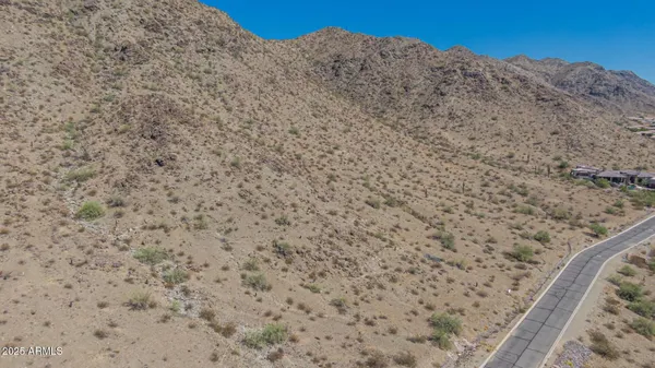 a view of a dry yard with mountains in the background