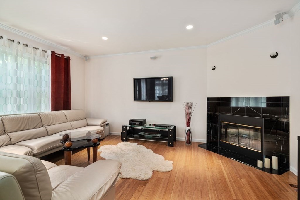 16 Ludwig Road, Unit 16 Needham, MA 02494 - Photo 10 of 33 a living room with furniture a flat screen tv and a fireplace