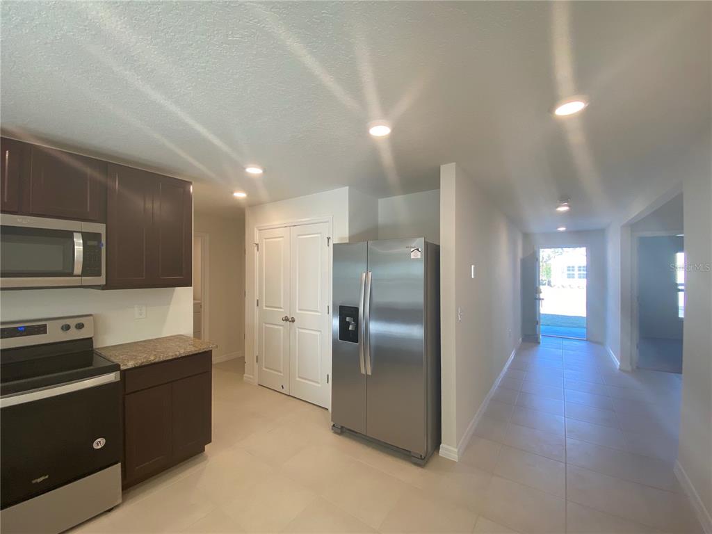 308 Hickory Course Radiel Ocala, FL 34472 - Photo 4 of 24 a kitchen with stainless steel appliances kitchen island granite countertop a refrigerator and a sink