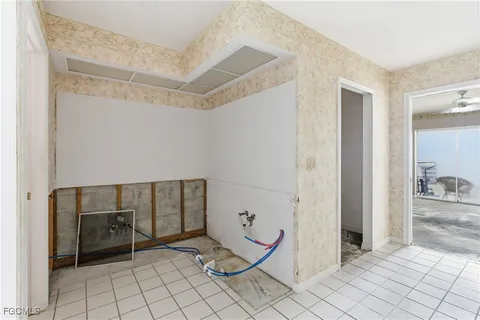 an empty room with a chandelier fan and windows