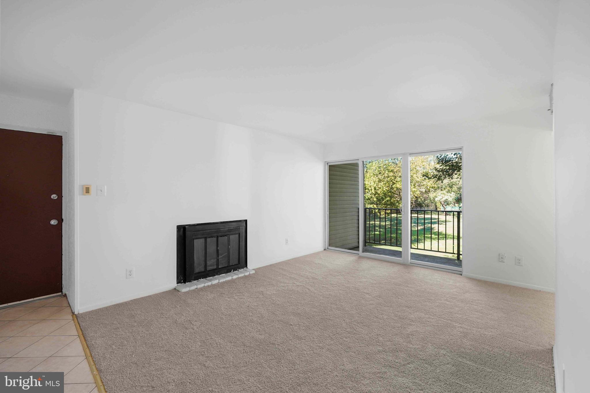 106 Duvall Lane, Unit 43 Gaithersburg, MD 20877 - Photo 6 of 38 a view of an empty room with a window and a kitchen