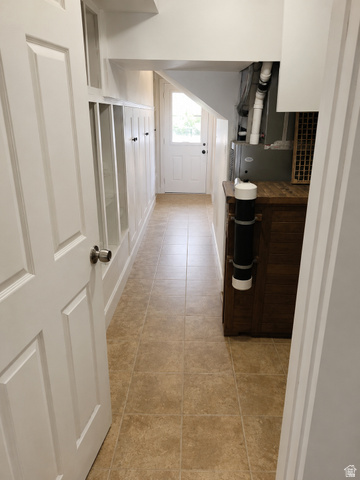 1225 South Main Street Mapleton, UT 84664 - Photo 17 of 21 Mudroom with built-in cubbies and hooks, tiled flooring, white painted trim, white paneled door, and natural light from exterior door