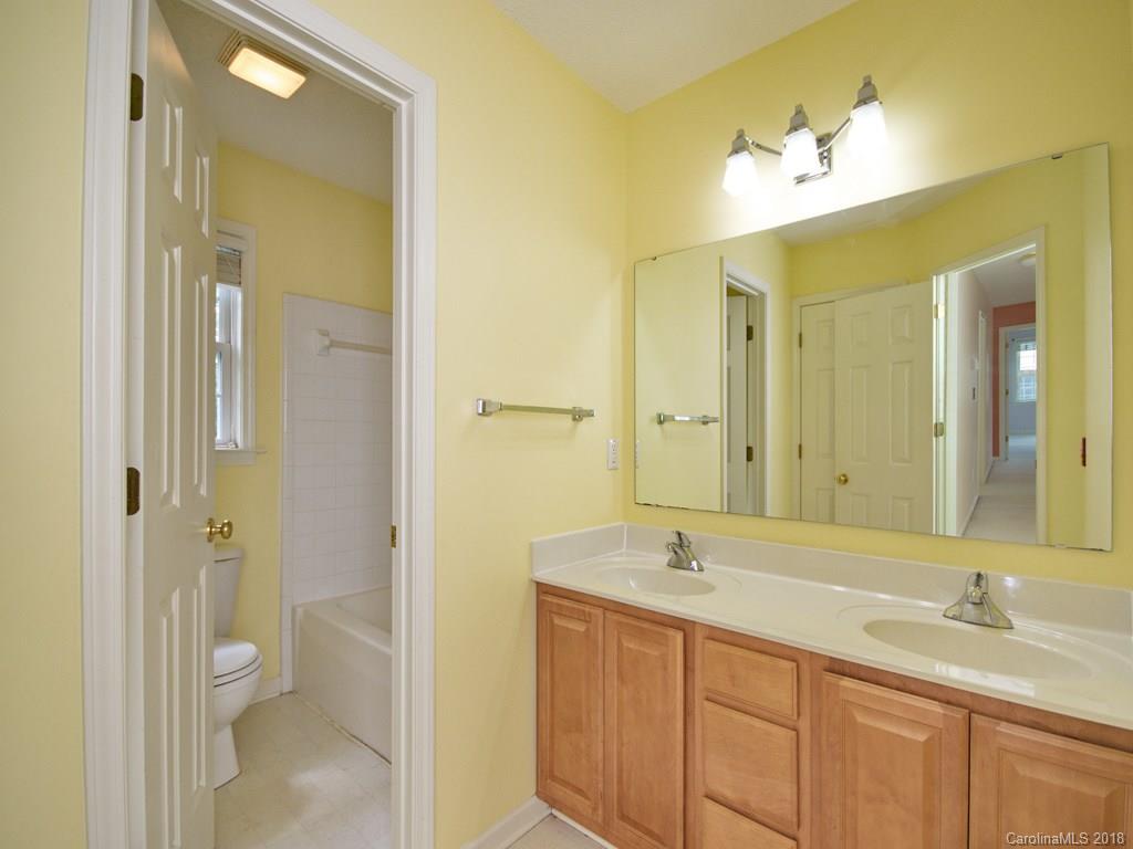 218 Walnut Crest Road, Unit 258 Fletcher, NC 28732 - Photo 18 of 24 a bathroom with a granite countertop sink mirror and a shower