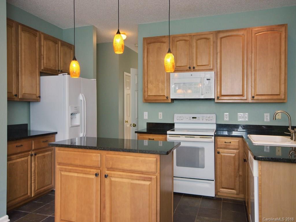 218 Walnut Crest Road, Unit 258 Fletcher, NC 28732 - Photo 8 of 24 a kitchen with kitchen island granite countertop wooden cabinets and white appliances