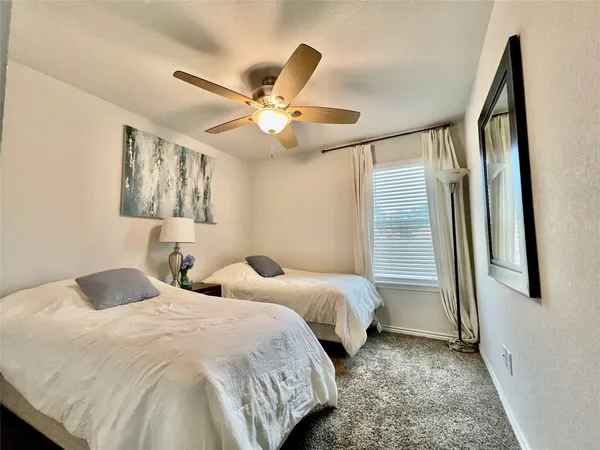 a bedroom with two beds and a large window