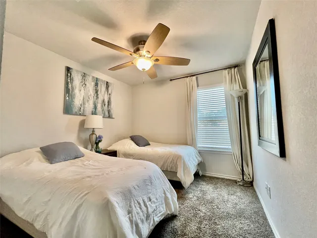 a bedroom with two beds and a large window