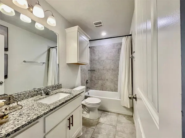 a bathroom with a granite countertop sink toilet and shower