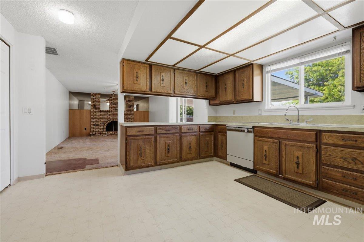 1311 North Middleton Road Nampa, ID 83651 - Photo 35 of 49 Kitchen featuring extensive wood cabinetry, light countertops, and a white dishwasher