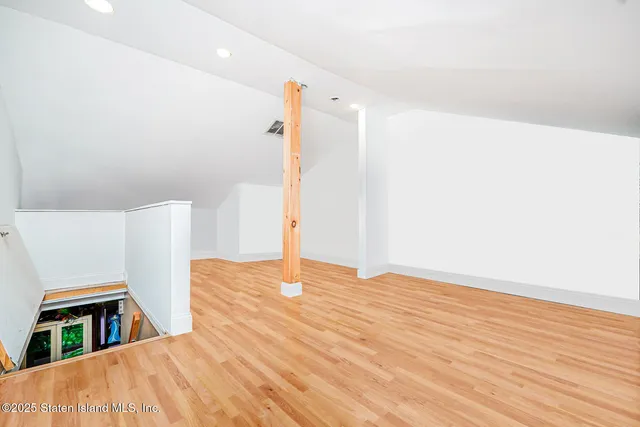 a view of empty room with wooden floor