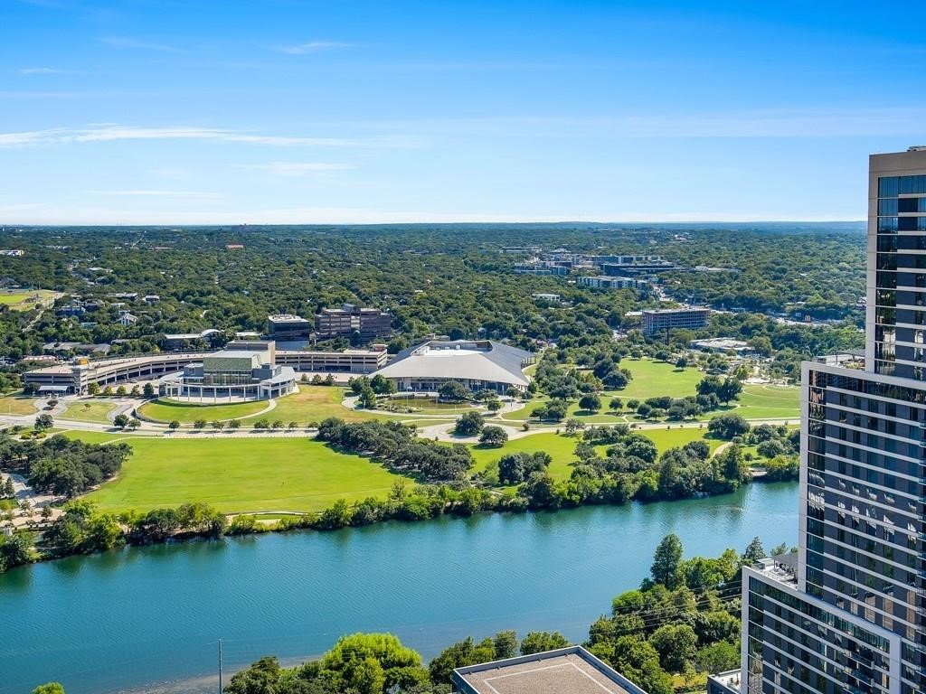 an aerial view of residential houses with outdoor space and lake view