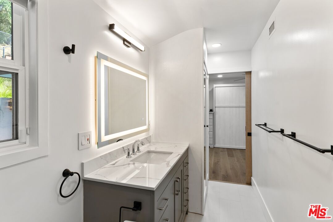 4118 Oak Hollow Road Calabasas, CA 91302 - Photo 48 of 55 a bathroom with a sink and a mirror