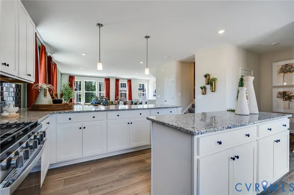 a kitchen with stainless steel appliances granite countertop a sink a stove and a wooden floors