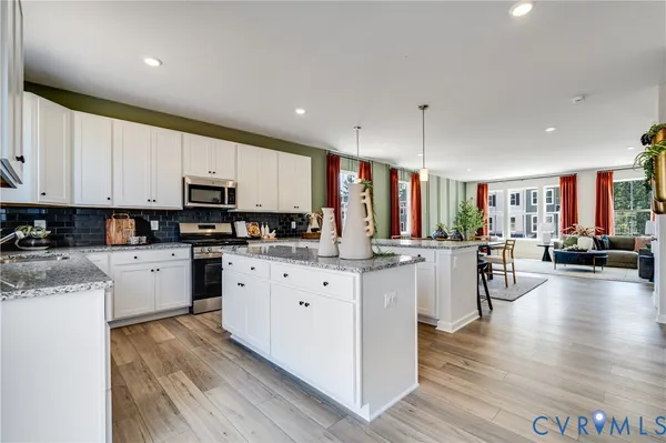 a kitchen with stainless steel appliances granite countertop lots of counter top space and a wooden floors