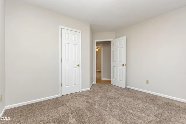 an empty room with closet and a chandelier fan
