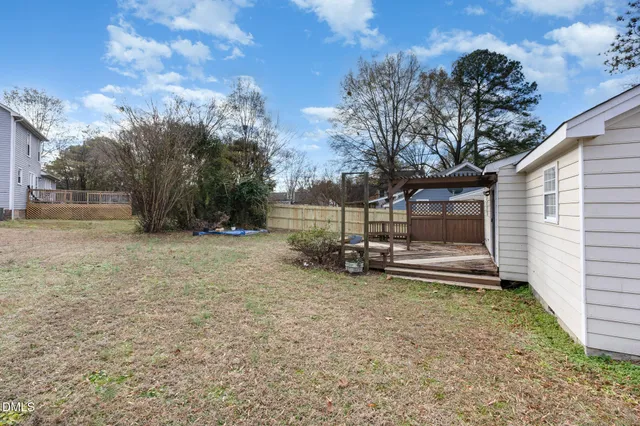 a view of a house with backyard and a tree