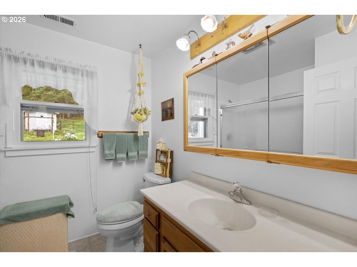 2277 Cougar Creek Road Oakland, OR 97462 - Photo 16 of 34 a bathroom with a sink a toilet and mirror