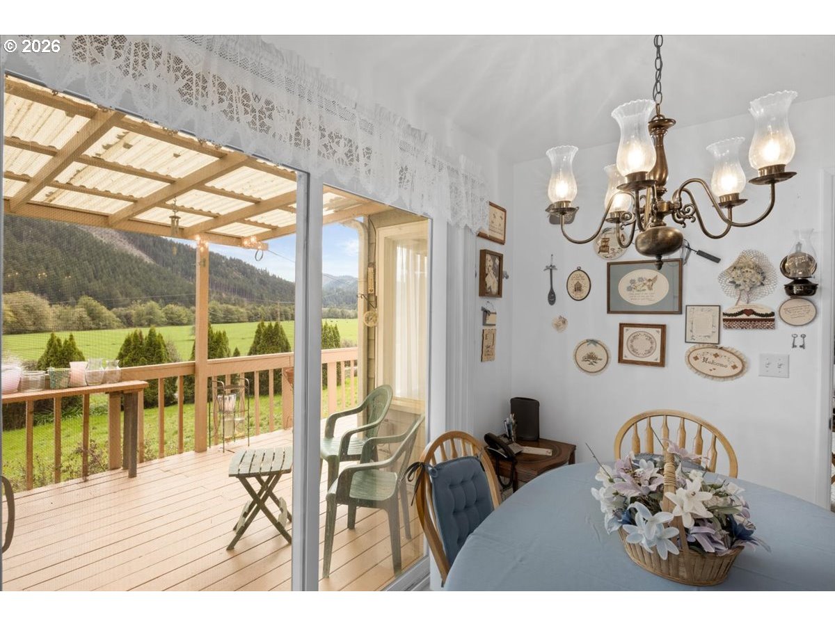 2277 Cougar Creek Road Oakland, OR 97462 - Photo 10 of 34 a view of a dining room with furniture a chandelier and wooden floor