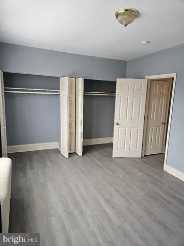 an empty room with wooden floor and closet