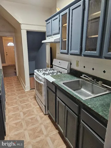 a kitchen with a sink stove and cabinets