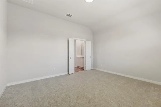an empty room with wooden floor chandelier fan and windows