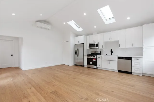 a view of kitchen with stainless steel appliances refrigerator oven stove microwave and cabinets