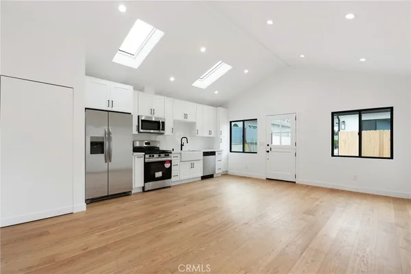 a kitchen with stainless steel appliances a refrigerator and a stove top oven