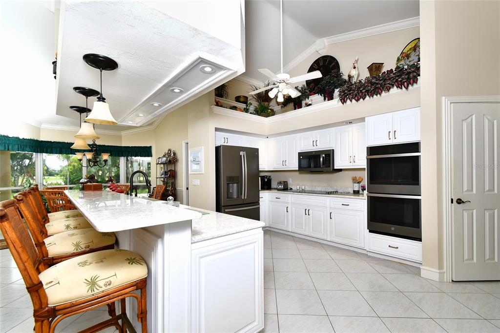 6030 Key Largo Circle Punta Gorda, FL 33955 - Photo 12 of 44 a room with stainless steel appliances kitchen island granite countertop a stove a refrigerator a oven a sink a dining table and chairs with wooden floor