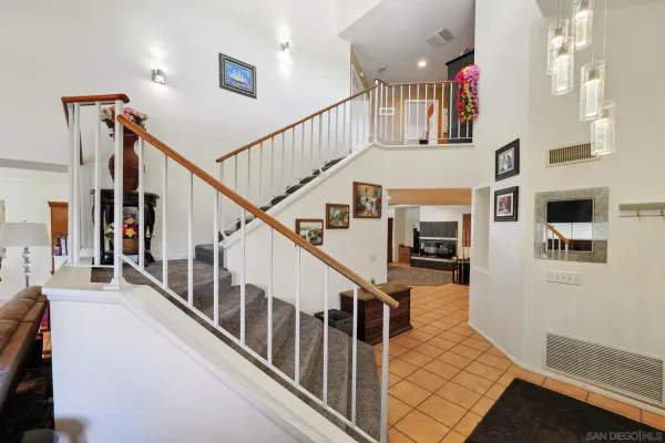 a view of staircase with lots of frames on wall and a window