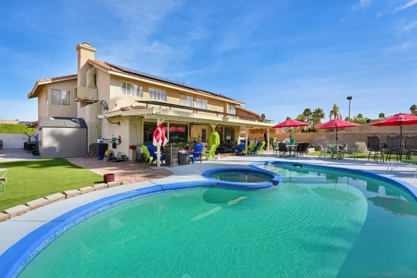 a swimming pool view with a seating space and garden