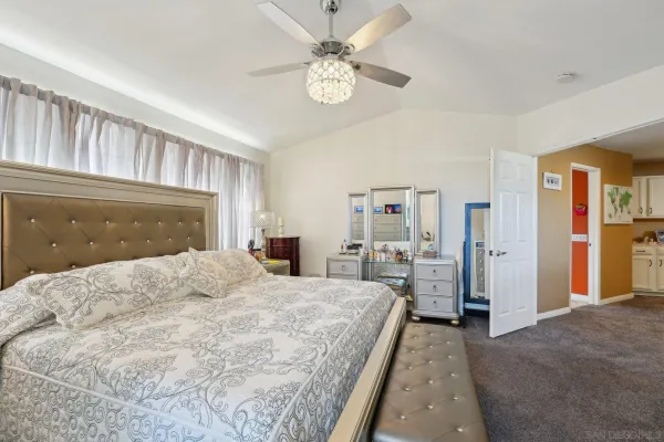 a bedroom with a large bed and a chandelier