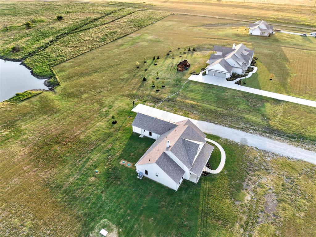 10978 Gregory Road Sanger, TX 76266 - Photo 40 of 40 Expansive green landscape with a prominent pond feature