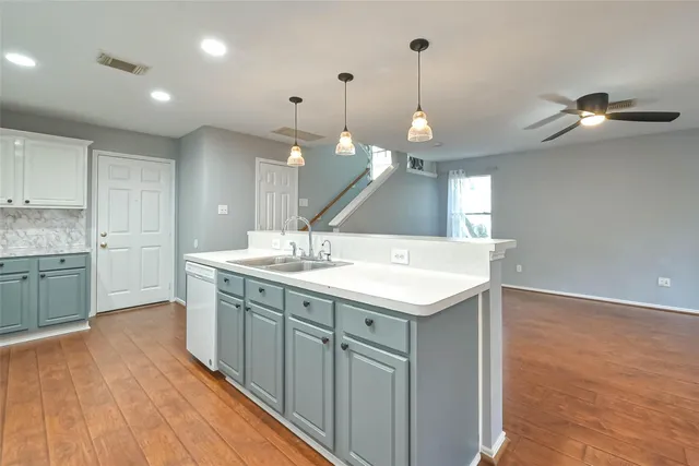 a kitchen with a sink cabinets and wooden floor
