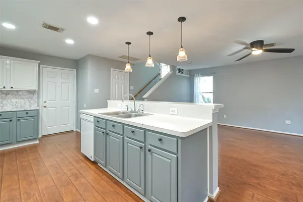 a kitchen with a sink cabinets and wooden floor