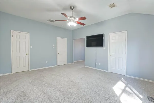 an empty room with a chandelier fan and a ceiling fan