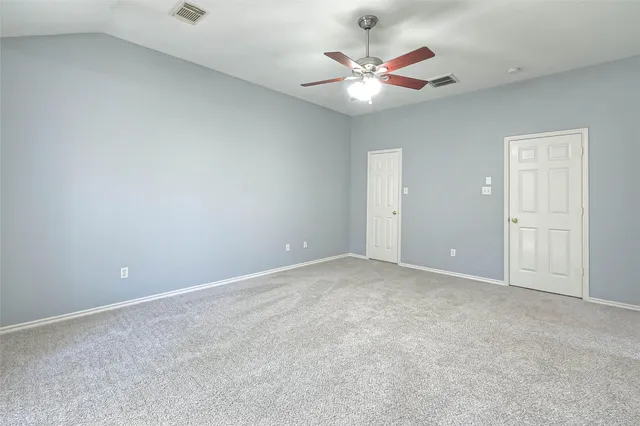 an empty room with a chandelier fan and a ceiling fan