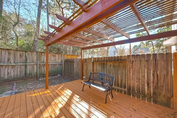 a view of a patio with a table and chairs and wooden fence