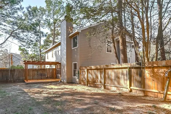 a view of backyard with wooden fence and large trees