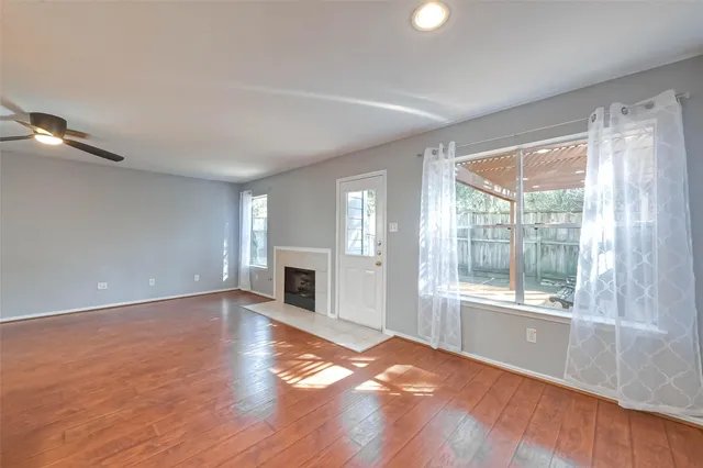 a view of empty room with wooden floor and fireplace