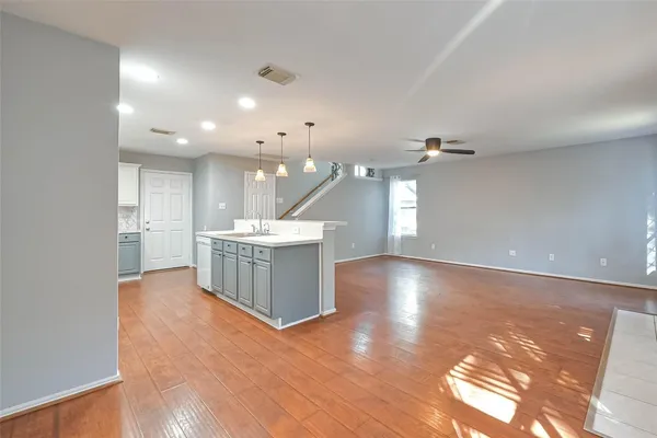 a view of a kitchen with a sink and dishwasher with wooden floor