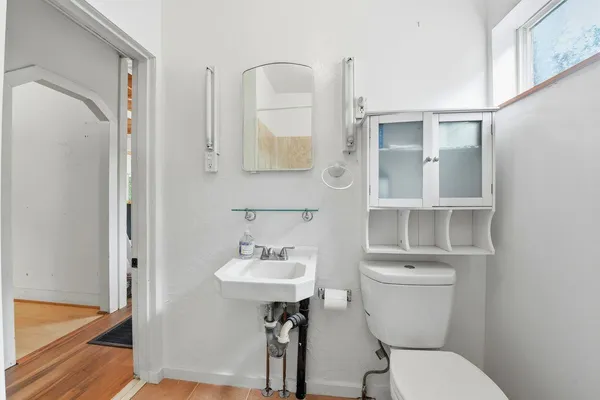 a bathroom with a toilet a sink and mirror