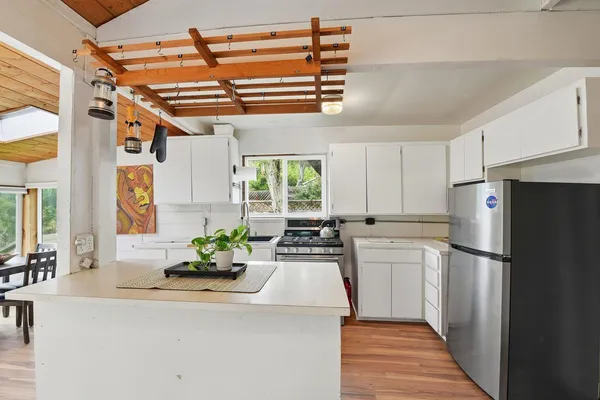a kitchen with stainless steel appliances a refrigerator a stove a sink and a refrigerator